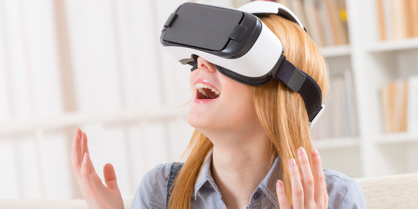Happy woman using virtual reality headset at home